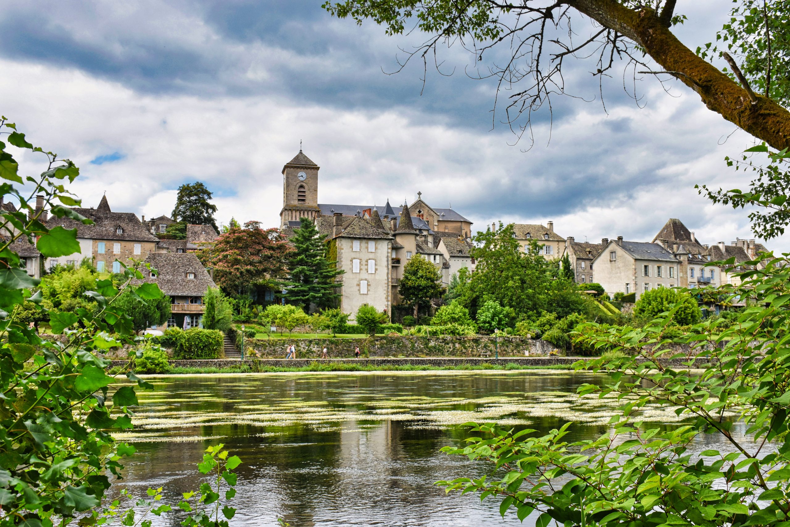 Medieval city by a river with greenery