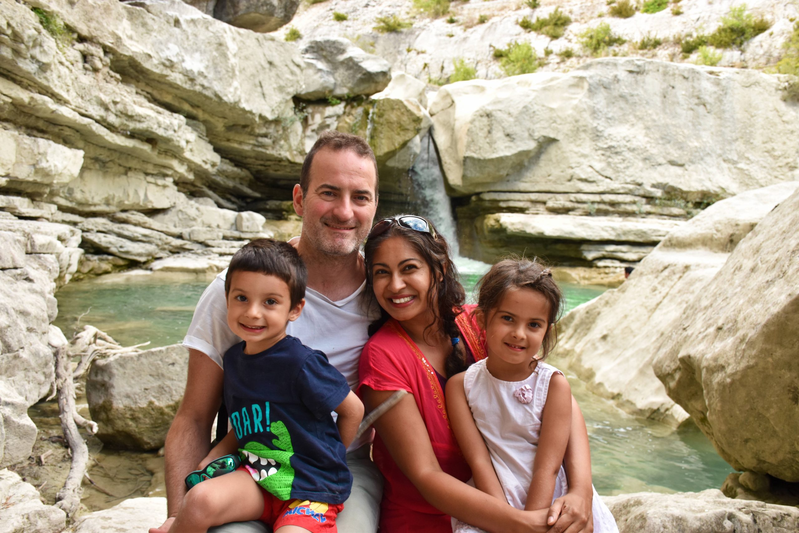 Family in rocky mountains with small waterfall