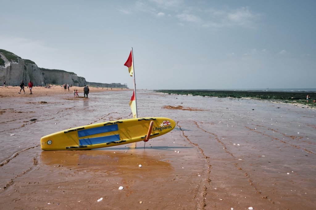 a yellow boat sitting on top of a sandy beach