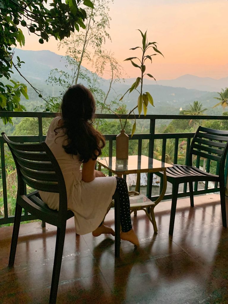 Girl on a balcony with a sunset in mountain