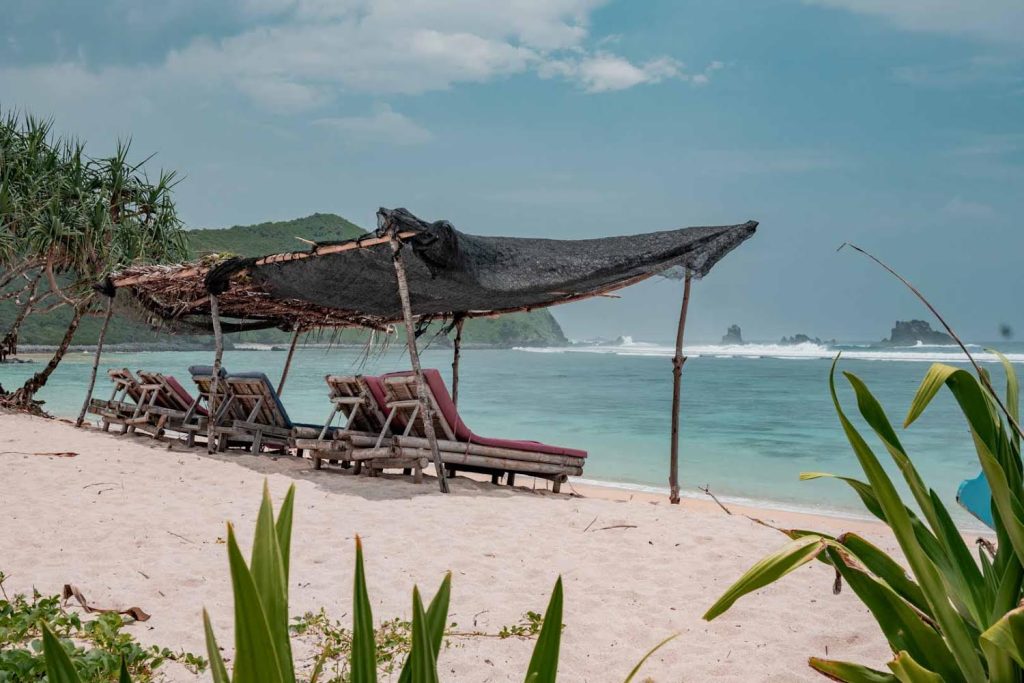 beach beds on a white sand beach with blue water lagoon