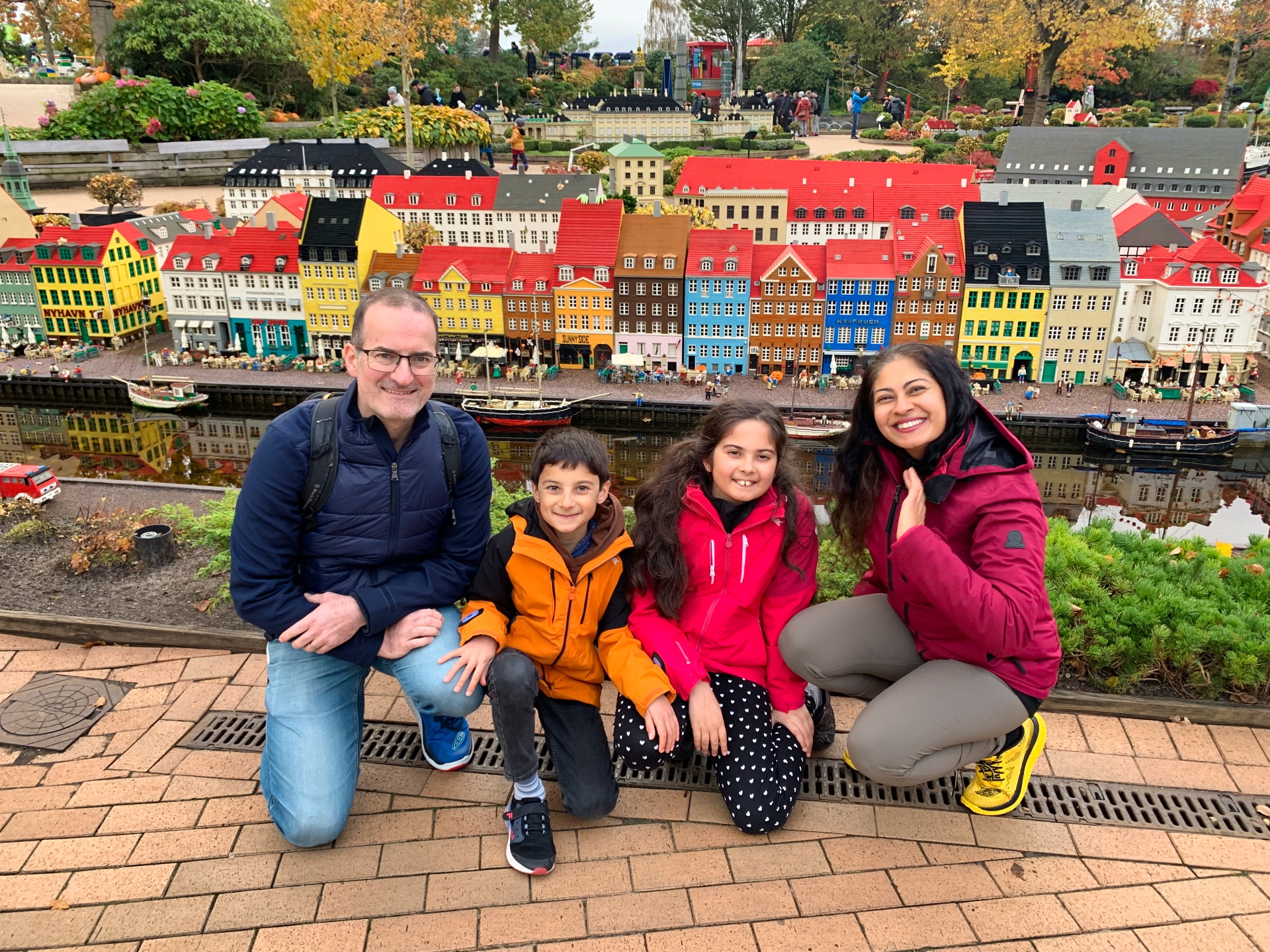 Family posing in front of a mini lego city