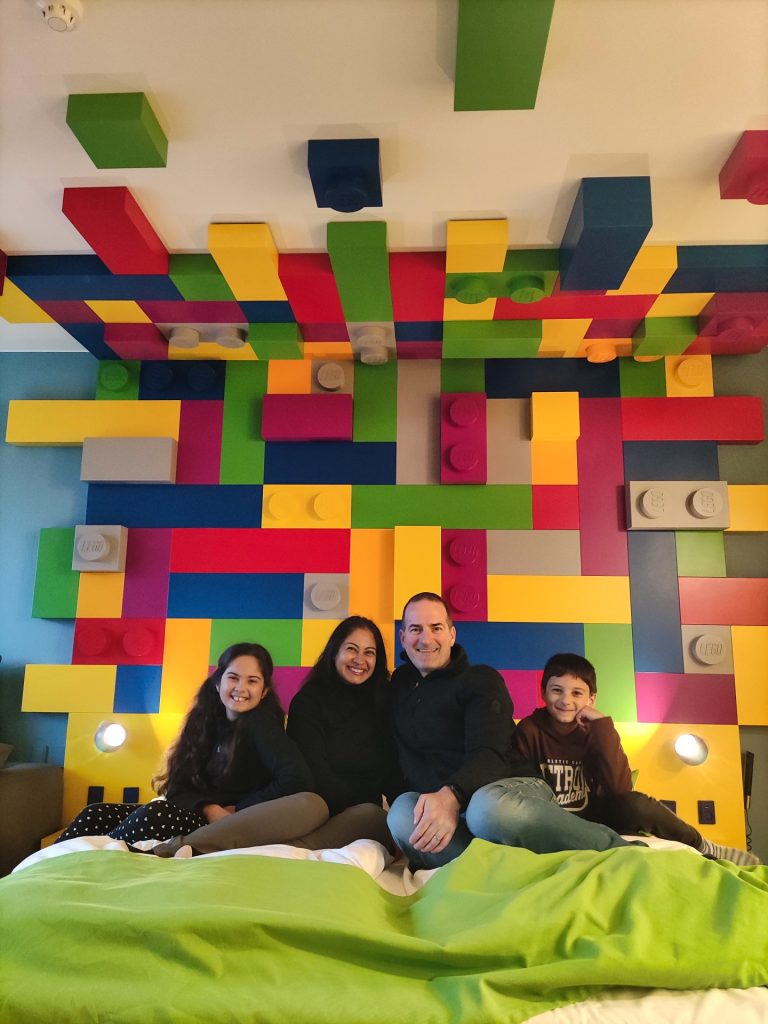 Billund with kids. Family sitting on a lego bed in a lego bedroom