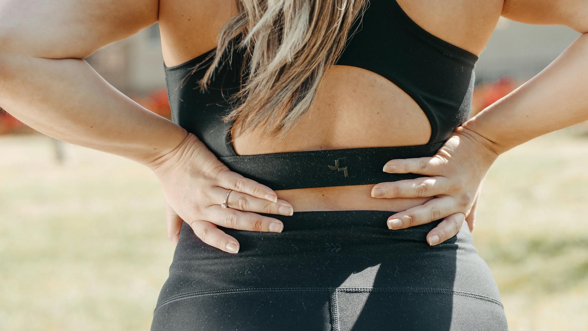 a woman wearing black active wear holding her waist