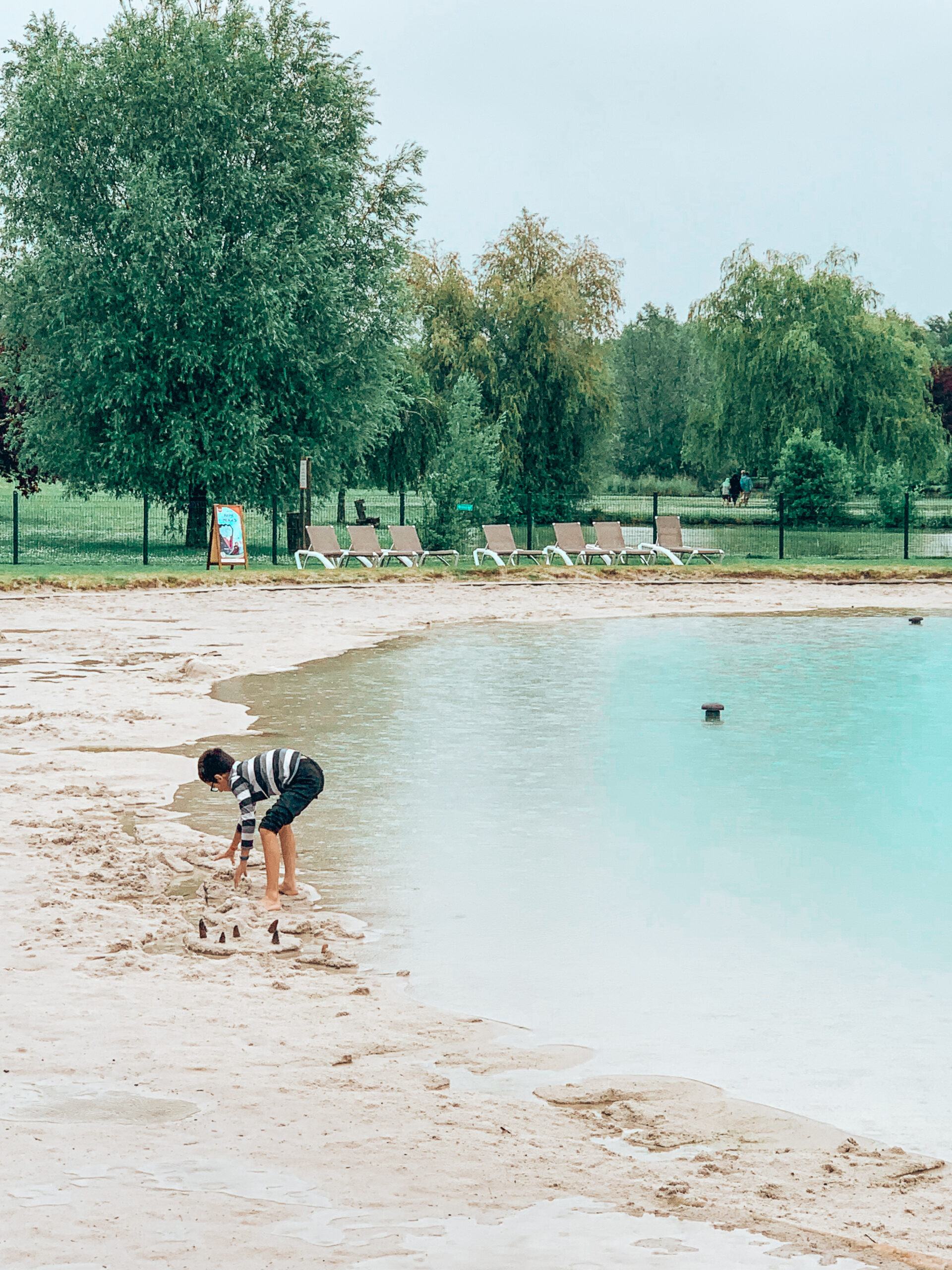 Boy Playing near blue water