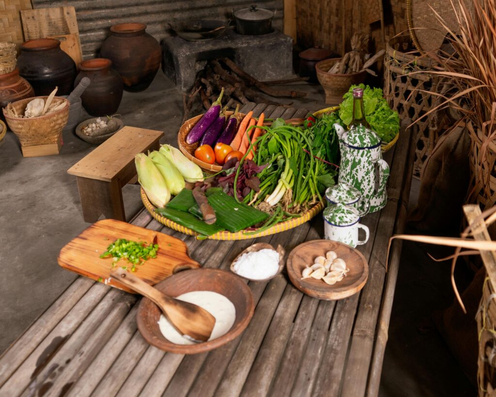 A rustic kitchen setting with a variety of fresh vegetables and cooking supplies on display, ideal for culinary themes.